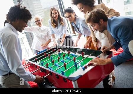I dipendenti tavolo da gioco calcio gioco al coperto in ufficio durante il tempo di interruzione Foto Stock