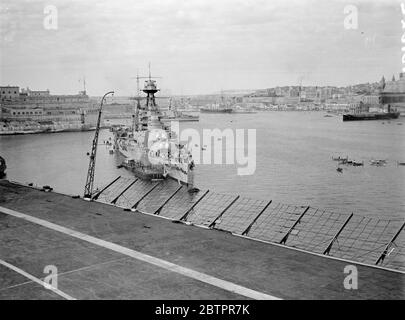 La nave da guerra più grande del mondo a Malta. HMS Hood, la più grande nave da guerra del mondo ancora nel porto di Valletta, capitale di Malta, dove le navi della Marina britannica massacrarono prima di partire per gli esercizi combinati della flotta Home e Mediterranea, trasferiti nell'Atlantico meridionale, a causa del pericolo nelle acque spagnole. Dietro 'Hood' si trova la città di la Valletta, che contiene molte reliquie dell'occupazione degli antichi Cavalieri di Malta. Questa foto è stata presa da 'HMS coraggioso' mentre la portaerei stava entrando nel porto. 5 marzo 1937 Foto Stock