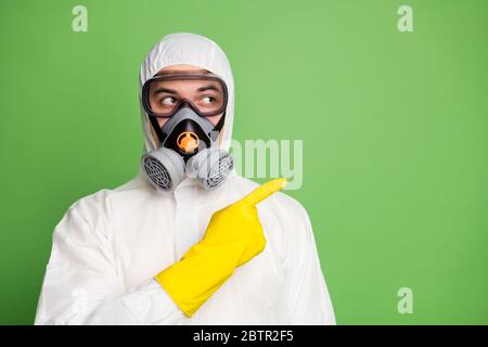 Primo piano ritratto del suo dottore disinfettante professionista esperto e piacevole doc indossare maschera a gas che mostra la soluzione senso direzione spazio copia Foto Stock