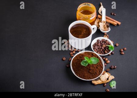 Composizione su fondo di un tuono con latte, caffè profumato, carmela salata, funghi secchi, menta. Caffè tendenza con funghi Foto Stock