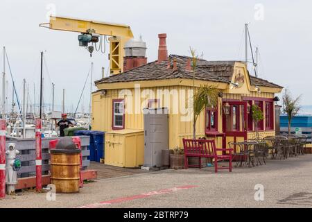 Monterey, California, USA - 09 giugno 2015: Vista dell'edificio giallo in legno del ristorante al Municipal Wharf. Gru gialla sullo sfondo. Foto Stock