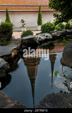 Giardino stagno a Wat Pho con il riflesso di cupole in acqua. Foto Stock