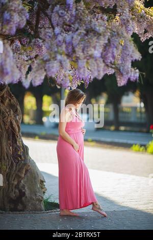 Bella donna incinta rilassante all'aperto nel parco. Foto Stock