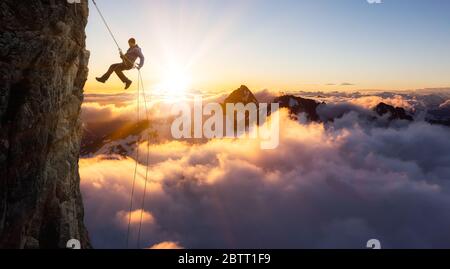 Epico avventuroso Extreme Sport composito di Rock Climbing Man Rappelling da una scogliera. Foto Stock