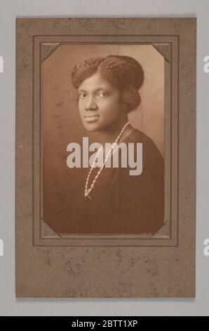 Stampa albumina di una donna non identificata. 2013.46.29.121a: Fotografia in bianco e nero di una donna non identificata. La donna è posta di fronte al lato sinistro della fotografia. La testa è rivolta verso la fotocamera. Indossa un abito scuro e una lunga collana di colore chiaro. Foto Stock