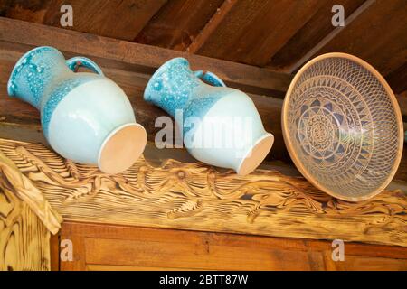 Autentiche caraffe blu smaltate in ceramica e tradizionale ciotola in argilla su sfondo di legno. Foto Stock