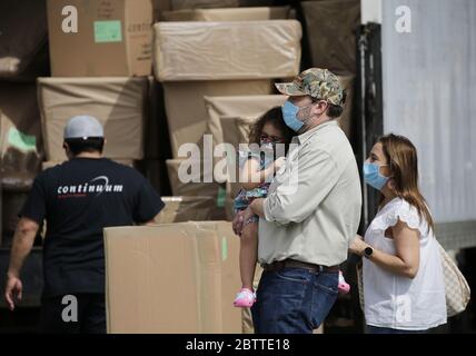 New York, Stati Uniti. 27 maggio 2020. Un uomo, una donna e un bambino che indossano maschere di protezione del viso cammina da un lavoratore e camion in movimento azienda nei giorni del Coronavirus Pandemic a New York City mercoledì 27 maggio 2020. I newyorkesi non possono essere sfrattati per non aver pagato il loro affitto nel corso della crisi del coronavirus. Gov. Andrew M. Cuomo ha recentemente annunciato un'estensione di 60 giorni fino ad agosto 20 di una moratoria che era prevista per la fine di giugno. Più di 5.5 milioni di casi di COVID-19 sono stati segnalati in tutto il mondo, con oltre 345,000 decessi. Foto di John Angelillo/UPI Credit: UPI/Alamy Live News Foto Stock