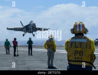 Un aereo da combattimento US Navy F/A-18F Super Hornet, assegnato ai Cavalieri neri del VFA 154, si avvicina a atterrare sul ponte di volo della portaerei di classe Nimitz USS Theodore Roosevelt 26 maggio 2020 nel Mare delle Filippine. L'equipaggio negativo COVID è tornato dalla quarantena e la nave ha continuato il loro dispiegamento programmato nell'Indo-Pacifico. Foto Stock