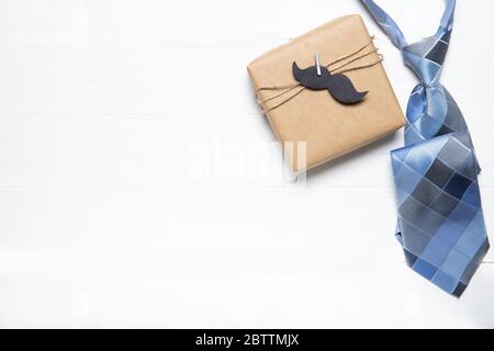 Cravatta e regalo per uomo su sfondo bianco di legno. Il concetto del giorno del papà. Posiziona per il testo Foto Stock