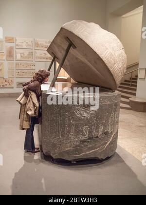 Donna che guarda all'interno di un antico sarcofago egiziano nel Metropolitan Museum of Art, New York, USA Foto Stock