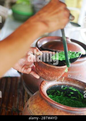 Un venditore indonesiano di degassini/cendol prepara l'ordine dell'acquirente al pomeriggio. Foto Stock