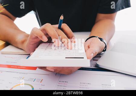 Primo piano uomo d'affari che usa calcolatrice e laptop per fare finanza matematica Foto Stock