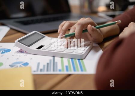 Vista ravvicinata del contabile o ispettore finanziario mani rendendo relazione, il calcolo o il controllo di equilibrio. Foto Stock