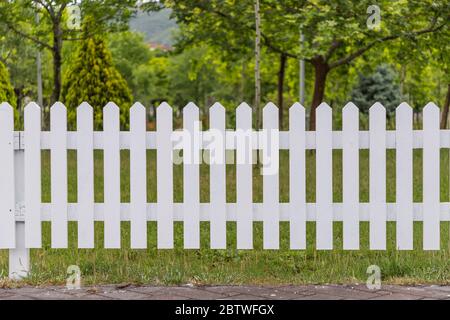 Recinzioni bianche in legno intorno al giardino Foto Stock