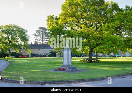 Monumento di guerra e alberi di quercia sul villaggio verde in primavera all'alba. Combe, Oxfordshire, Regno Unito Foto Stock