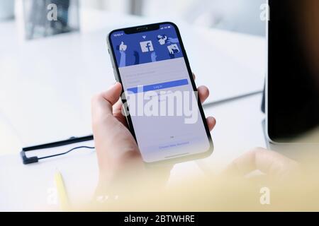 CHIANG mai ,THAILANDIA - MAR 7, 2020 : Donna mano che tiene iPhone XS per utilizzare facebook con la nuova schermata di login. Foto Stock
