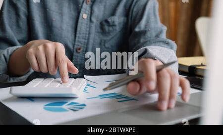 Donna d'affari o contabile che lavora su calcolatrice e computer portatile con documento finanziario, Foto Stock