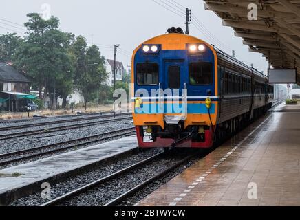 Unità diesel multiple del treno speciale espresso è arrivo alla stazione urbana in serata, aria condizionata diesel ferrovia (con guida c Foto Stock