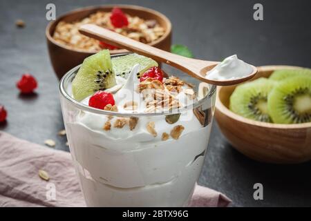 Yogurt greco con kiwi su lastra di pietra nera Foto Stock