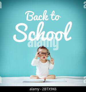 Bambino piccolo e lavagna con 'ritorno a scuola' sullo sfondo, concetto di scuola Foto Stock