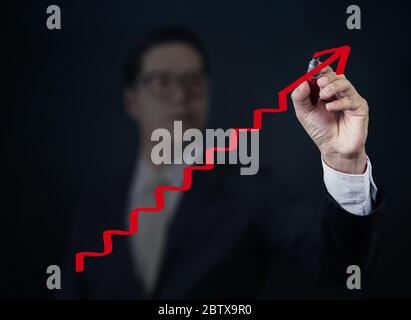 Uomo d'affari mano scrittura 'Graph' con marcatore rosso su tavola trasparente, nuovo concetto di business, studio shot Foto Stock