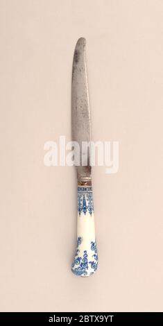 Coltello con manico in porcellana con motivi blu. Ricerca in ProgressLama a forma di Sabre, supporto liscio, piccola boccola in argento. Manico in porcellana bianca a forma di pistola con motivo floreale blu scuro e scrolled. Foto Stock