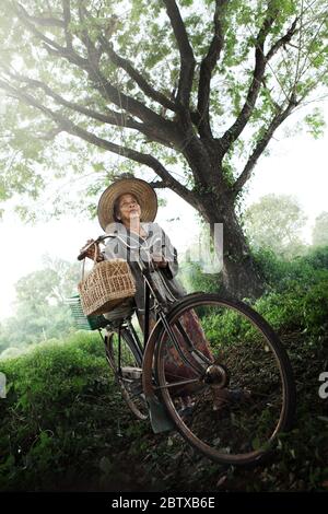 Felice Asian anziani anziani matura mountain bike nel parco Foto Stock