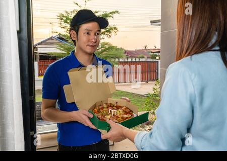 Consegna uomo consegna pizza cibo alla donna cliente a casa Foto Stock