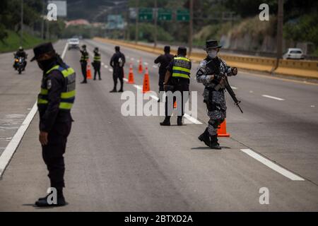 San Salvador, El Salvador. 17 maggio 2020. Ufficiali di polizia e soldati pesantemente armati che indossano maschere controllano i conducenti su un viale durante la pandemia di Corona. Il presidente del Salvador Bukele ha presentato un "piano di controllo territoriale", che finora consiste principalmente in una maggiore presenza militare. (A dpa 'Twittering monarca: El Salvador 'Cool' presidente polarizzato' dal 28.05.2020) Credit: Víctor Peña/dpa/Alamy Live News Foto Stock