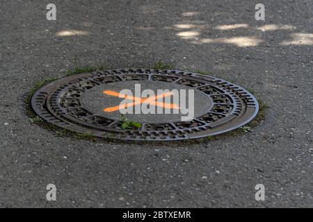 tondeggiante fogna in acciaio sulla strada Foto Stock