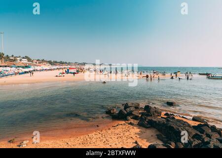 Mapusa, Anjuna, Goa, India. La gente visita e rilassarsi sulla spiaggia di Baga alla Sunny Evening sotto il cielo blu Foto Stock