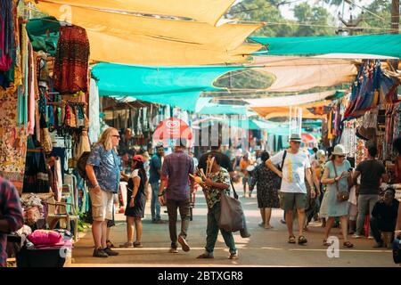 Anjuna, Goa, India - 19 febbraio 2020: Il venditore di strumenti musicali vende i flauti indiani tradizionali ad UN turista nel mercato di Anjuna. Foto Stock