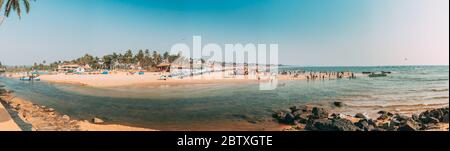 Mapusa, Anjuna, Goa, India - 19 febbraio 2020: La gente visita e si rilassa sulla spiaggia di Baga alla sera di sole sotto il cielo blu. Panorama Foto Stock