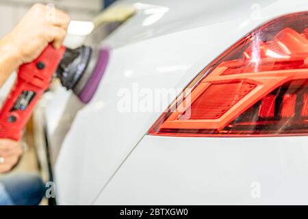 riparazione della carrozzeria della vettura mediante lucidatura con smerigliatrice. con applicazione di cera e protezione della vernice Foto Stock