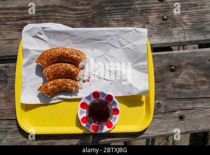 Bagel e un bicchiere di tè turco sul vassoio all'esterno. Foto Stock