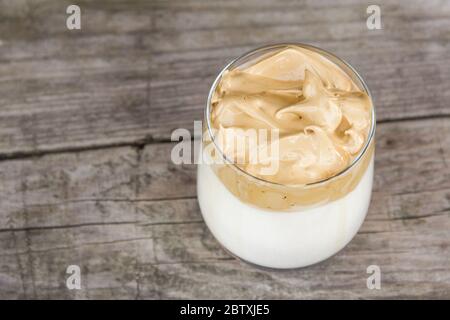 Caffè Dalgona su rustico sfondo di legno. Foto Stock