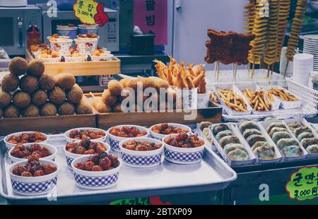 Busan, Corea del Sud, 14 settembre 2019: Varietà di cibo di strada coreano in esposizione: Cani da mais, patatine fritte, pollo fritto Foto Stock