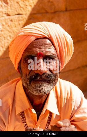 Ritratto di un uomo da Jaisalmer in piedi nel deserto del Thar con turban colorato, Jaisalmer, Rajasthan Foto Stock