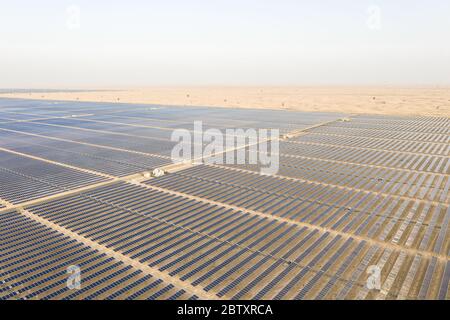 Vista aerea di pannelli solari fotovoltaici e trasformatori che producono energia rinnovabile sostenibile in una centrale elettrica del deserto. Foto Stock