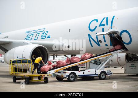 (200528) -- CHANGSHA, 28 maggio 2020 (Xinhua) -- UN membro del personale mette le parcelle delle attività transfrontaliere di e-commerce su un nastro trasportatore presso l'aeroporto internazionale Changsha Huanghua di Changsha, provincia di Hunan, 28 maggio 2020. Un aereo che trasportava quasi 40,000 pacchi dalle imprese transfrontaliere di e-commerce partì da Changsha a Mosca, Russia, giovedì. Questo è stato il primo volo della normale rotta aerea per il trasporto merci sul commercio elettronico transfrontaliero verso la Russia, il che significa il funzionamento di tale rotta in Hunan. Operata tre volte alla settimana, il percorso servirà come Foto Stock