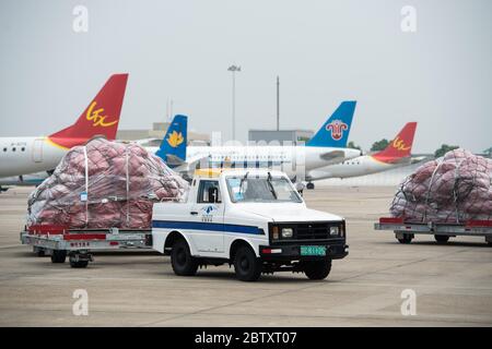 (200528) -- CHANGSHA, 28 maggio 2020 (Xinhua) -- UN trattore trasporta i pacchi dalle imprese transfrontaliere di commercio elettronico al piazzale di parcheggio presso l'aeroporto internazionale Changsha Huanghua di Changsha, provincia di Hunan, 28 maggio 2020. Un aereo che trasportava quasi 40,000 pacchi dalle imprese transfrontaliere di e-commerce partì da Changsha a Mosca, Russia, giovedì. Questo è stato il primo volo della normale rotta aerea per il trasporto merci sul commercio elettronico transfrontaliero verso la Russia, il che significa il funzionamento di tale rotta in Hunan. Operato tre volte alla settimana, il percorso servirà da d Foto Stock