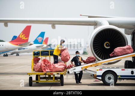 (200528) -- CHANGSHA, 28 maggio 2020 (Xinhua) -- il personale ha messo i pacchi delle attività transfrontaliere di e-commerce su un nastro trasportatore presso l'aeroporto internazionale Changsha Huanghua di Changsha, provincia di Hunan, 28 maggio 2020. Un aereo che trasportava quasi 40,000 pacchi dalle imprese transfrontaliere di e-commerce partì da Changsha a Mosca, Russia, giovedì. Questo è stato il primo volo della normale rotta aerea per il trasporto merci sul commercio elettronico transfrontaliero verso la Russia, il che significa il funzionamento di tale rotta in Hunan. Il percorso è operato tre volte alla settimana e sarà diretto Foto Stock