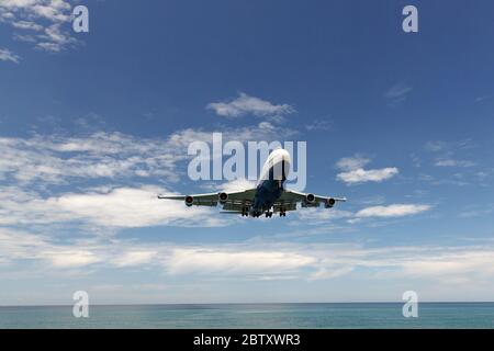 Vacanza, viaggio, concetto di aviazione. Moderno aereo commerciale jetliner volare in cielo blu sopra il mare, spazio copia. Vista dal basso. Foto Stock