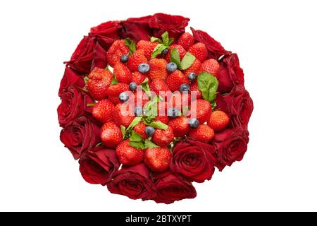 Delizioso bouquet di fragole, rose, mirtilli e foglie di menta. Vista piatta, isolata su bianco Foto Stock