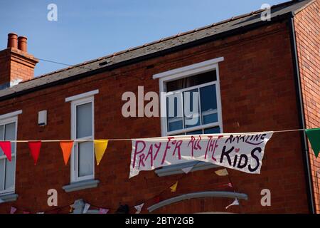 Duncombe Street a Wollaston, dove l'artista Luke Perry ha appeso bunting con messaggi di sostegno per i vicini e i lavoratori chiave, per creare un corridoio di 500 metri di colore attraverso il villaggio delle West Midlands. Perry ha chiesto ai residenti e ai negozianti locali di presentare disegni e messaggi, che poi dipinse a mano e cucì su conchettando con l'aiuto di volontari. Foto Stock