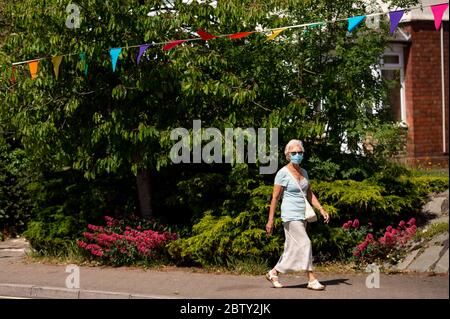 Wollaston High Street, dove l'artista Luke Perry ha appeso il bunging, con messaggi di sostegno per i vicini e i lavoratori chiave, per creare un corridoio di 500 metri di colore attraverso il villaggio delle West Midlands. Perry ha chiesto ai residenti e ai negozianti locali di presentare disegni e messaggi, che poi dipinse a mano e cucì su conchettando con l'aiuto di volontari. Foto Stock