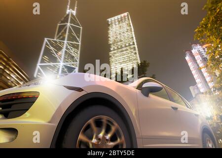 Rendering 3D di una vettura sportiva in movimento davanti allo skyline di Hong Kong. Foto Stock