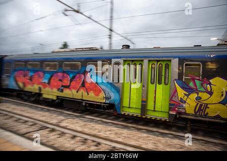 teni, italia maggio 28 2020 : treni che si impanano alla stazione a velocità con persone all'interno e colorate da graffiti Foto Stock