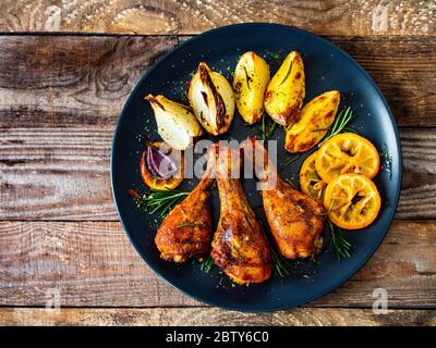 Costolette di pollo grigliate con patate e cipolle al forno Foto Stock