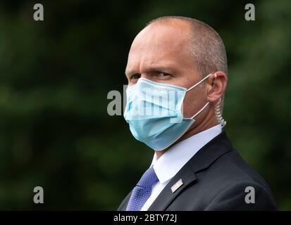 Un agente del servizio segreto indossa una maschera mentre guarda il presidente Donald Trump e la First Lady Melania Trump lasciare la Casa Bianca a Washington, DC mercoledì 27 maggio 2020. Il presidente Trump e la First Lady si recano al Kennedy Space Center della NASA per assistere al lancio della SpaceX Mission 2. Credit: Kevin Dietsch/Pool via CNP /MediaPunch Foto Stock